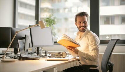 Mann in Büro dreht sich zur Seite und lächelt