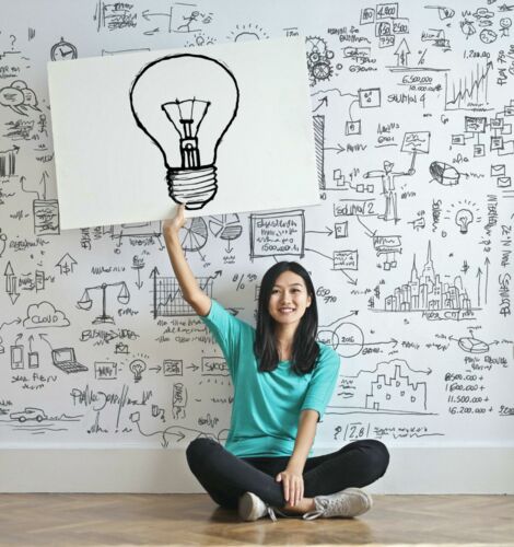 Frau hält Bild mit Glühlampe hoch
