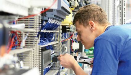 Junger Elektroniker arbeitet an Elektroinstallation