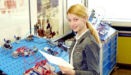 Mädchen an Übungstisch für Elektrotechnik
