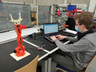 Junge programmiert während MINT-Projektwoche einen Roboterarm