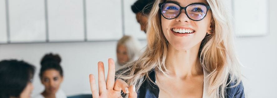 Junge Frau mit Brille lächelt in die Kamera