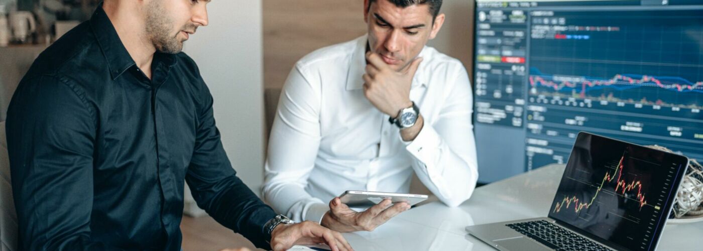 Männer an Tisch mit Laptop und Tablet