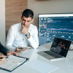 Männer an Tisch mit Laptop und Tablet