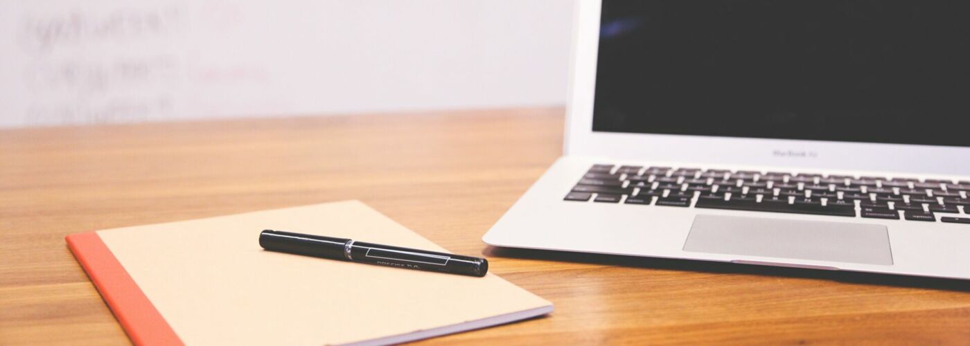 Notizblock, Stift und Laptop