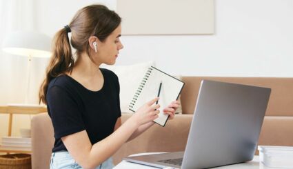 Frau zeigt Notizen in Videochat am Laptop