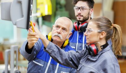 Auszubildende und Ausbilder an Maschine