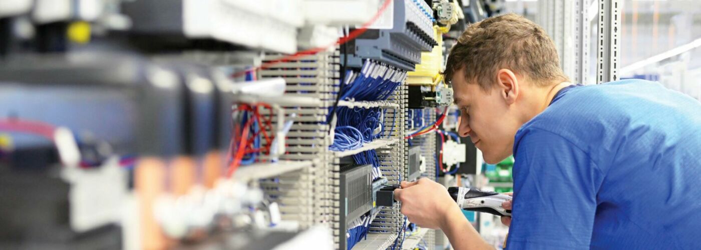 Junger Elektroniker arbeitet an Elektroinstallation