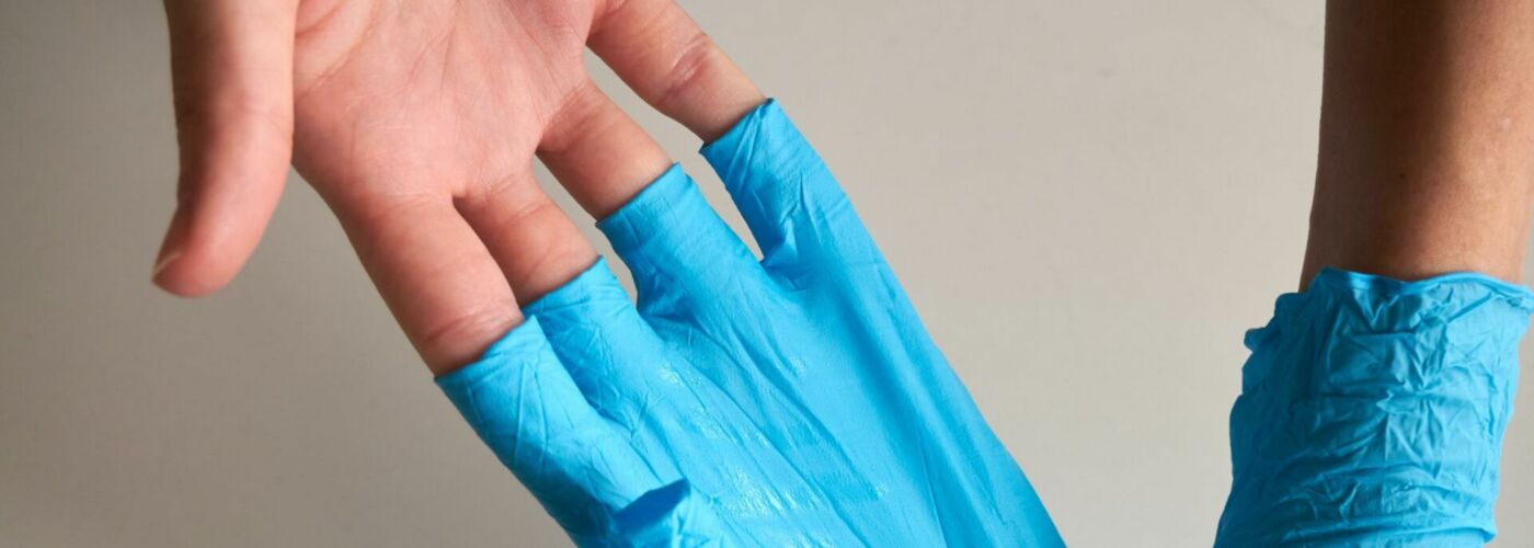Hände mit Gummihandschuhen