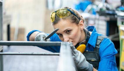 Konstruktionsmechanikerin arbeitet an einem Metallgestellt