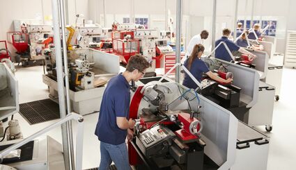 Auszubildende in Werkstatt arbeiten an Drehmaschinen