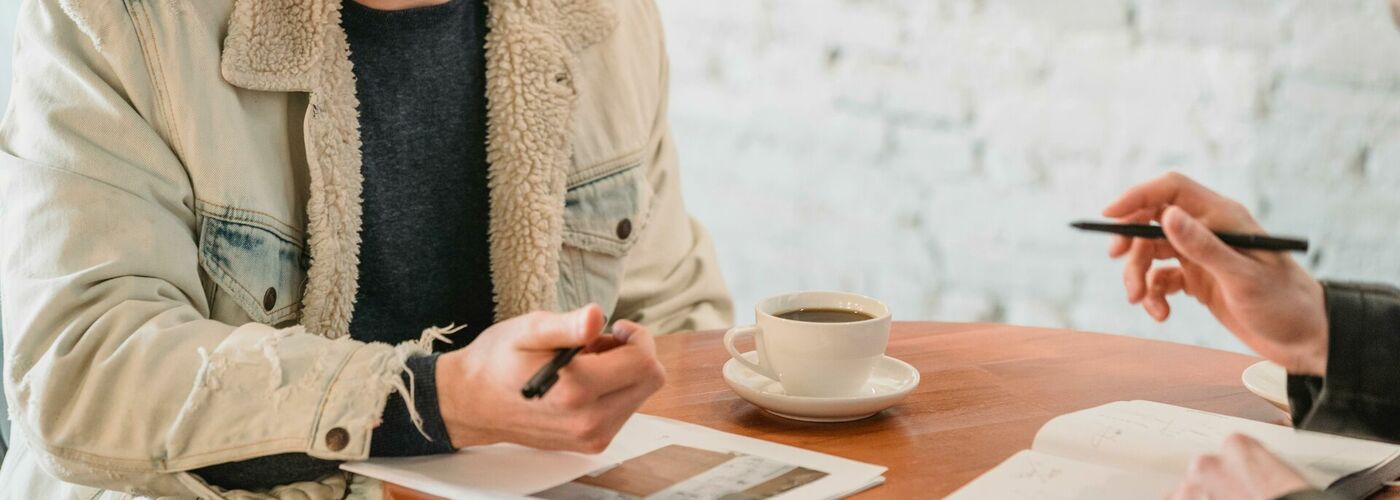 Mann sitzt an Tisch und unterhält sich