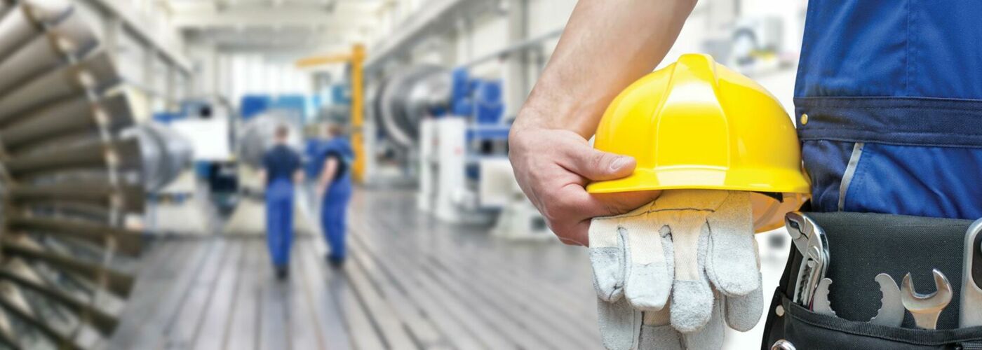 Große Werkstatt, Helm und Arbeitshandschuhe in der Hand