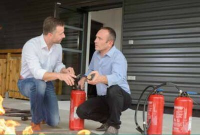 Zwei Männer, die sich über Feuerlöscher unterhalten
