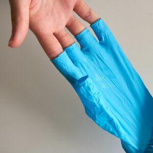 Hände mit Gummihandschuhen